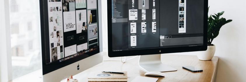 Zwei Imacs Mit Tastatur Und Telefonen Auf Dem Schreibtisch